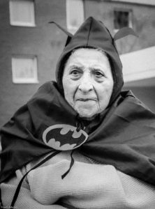 Das schwarz/weiß-Foto zeigt einen alten Menschen im Batman-Kostüm. Ein direkter Bezug zur Pflege fehlt zwear auf dem Foto, aber die abgebildete Person stammt tatsächlich aus einem Pflegeheim.